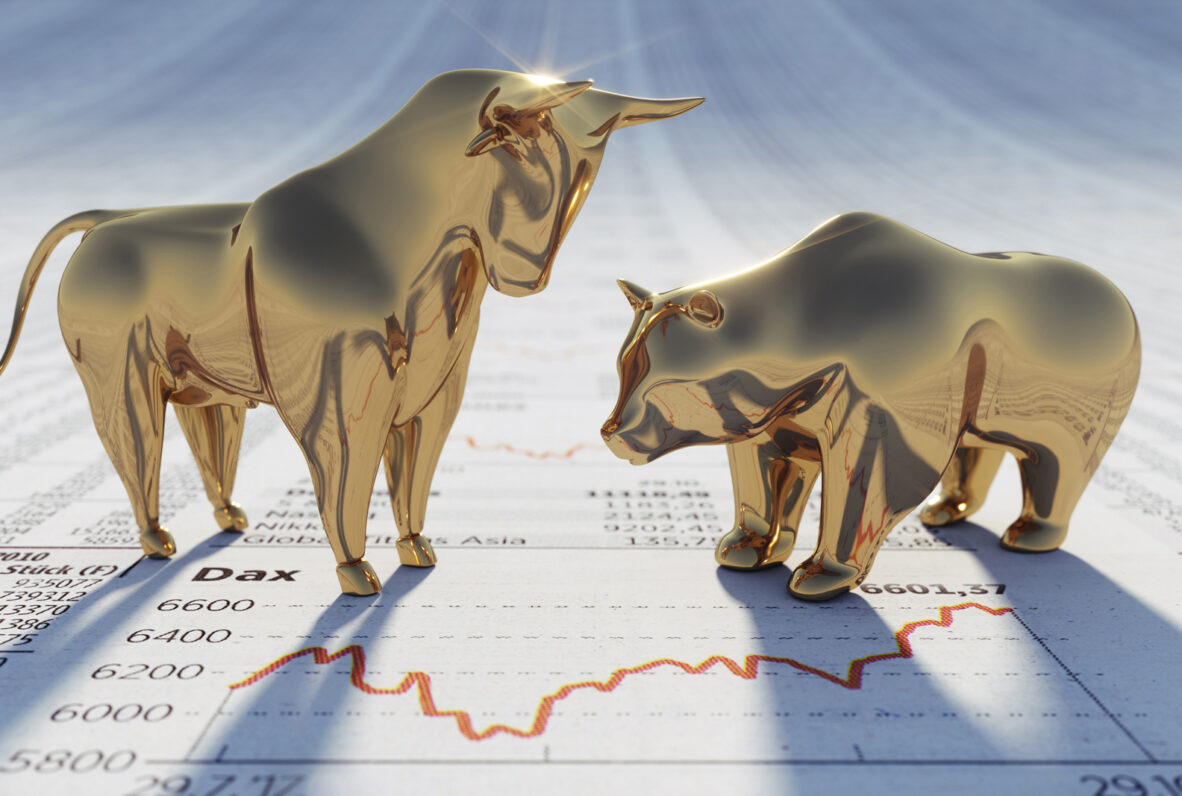 Goldene Bulle- und Bärenfiguren als Symbole für steigende und fallende Börsenkurse auf einer Finanzzeitung mit DAX-Diagramm.