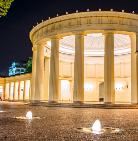 Nachts beleuchteter Elisenbrunnen mit klassizistischer Architektur in Aachen.