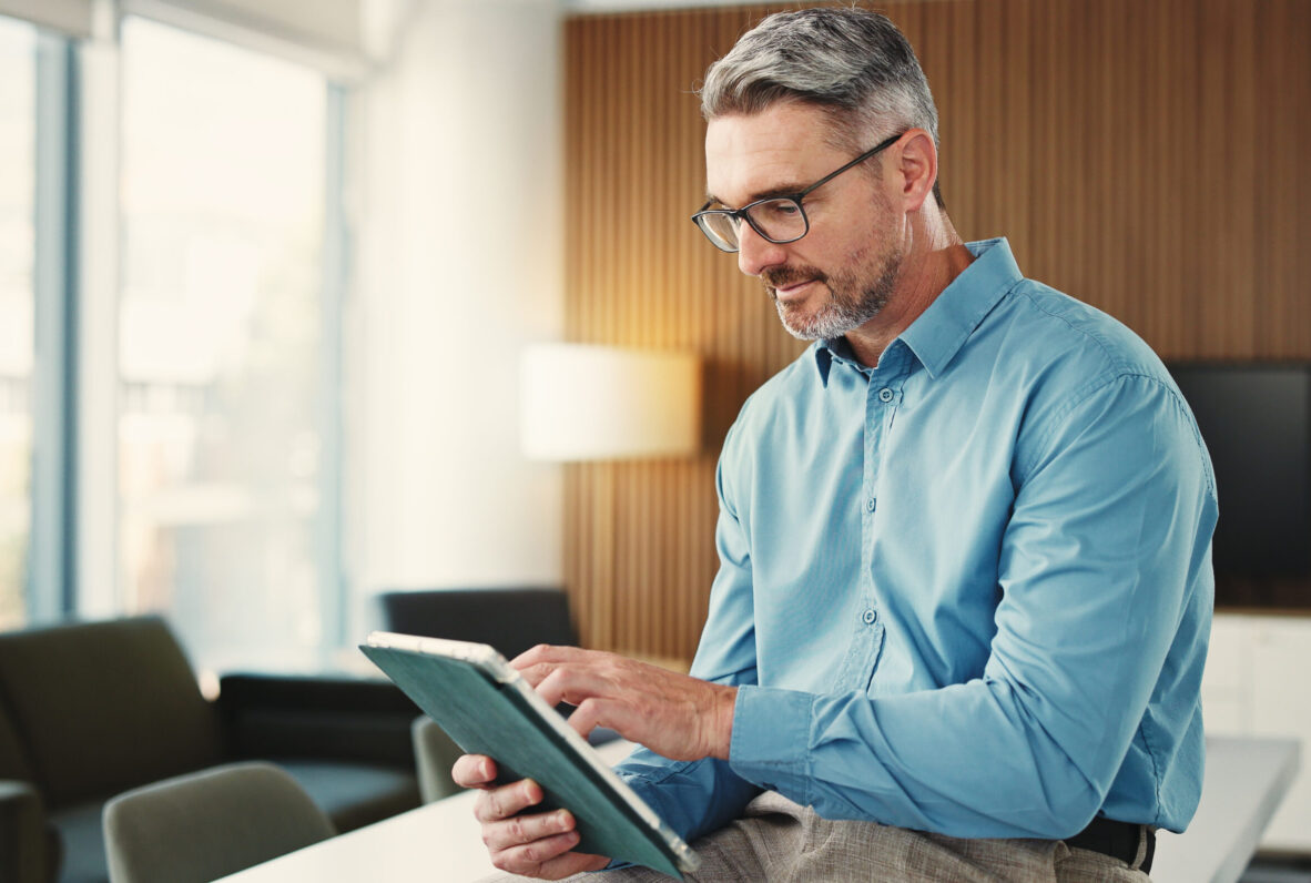 Business, tablet and mature man in office for finance review, investment and trading analyst. Professional, financial advisor and person on digital tech for stock market trends, research and profit.