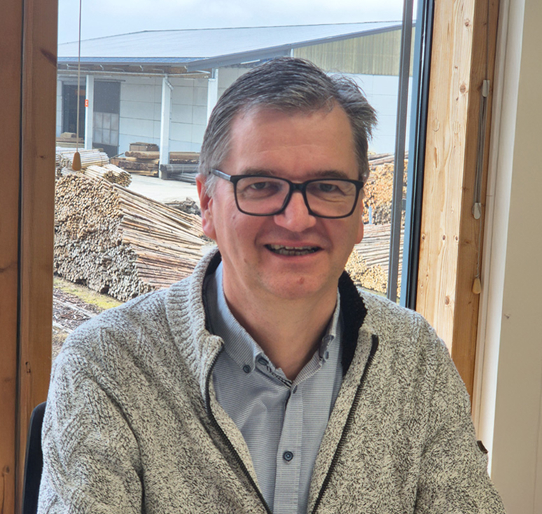 Gilbert Layens, Geschäftsführer der Peter Müller GmbH, am Schreibtisch mit Blick auf das Betriebsgelände.