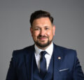 Sascha Brandt, Vice President UK/Benelux bei Norsk Hydro, im dunkelblauen Anzug vor grauem Hintergrund.